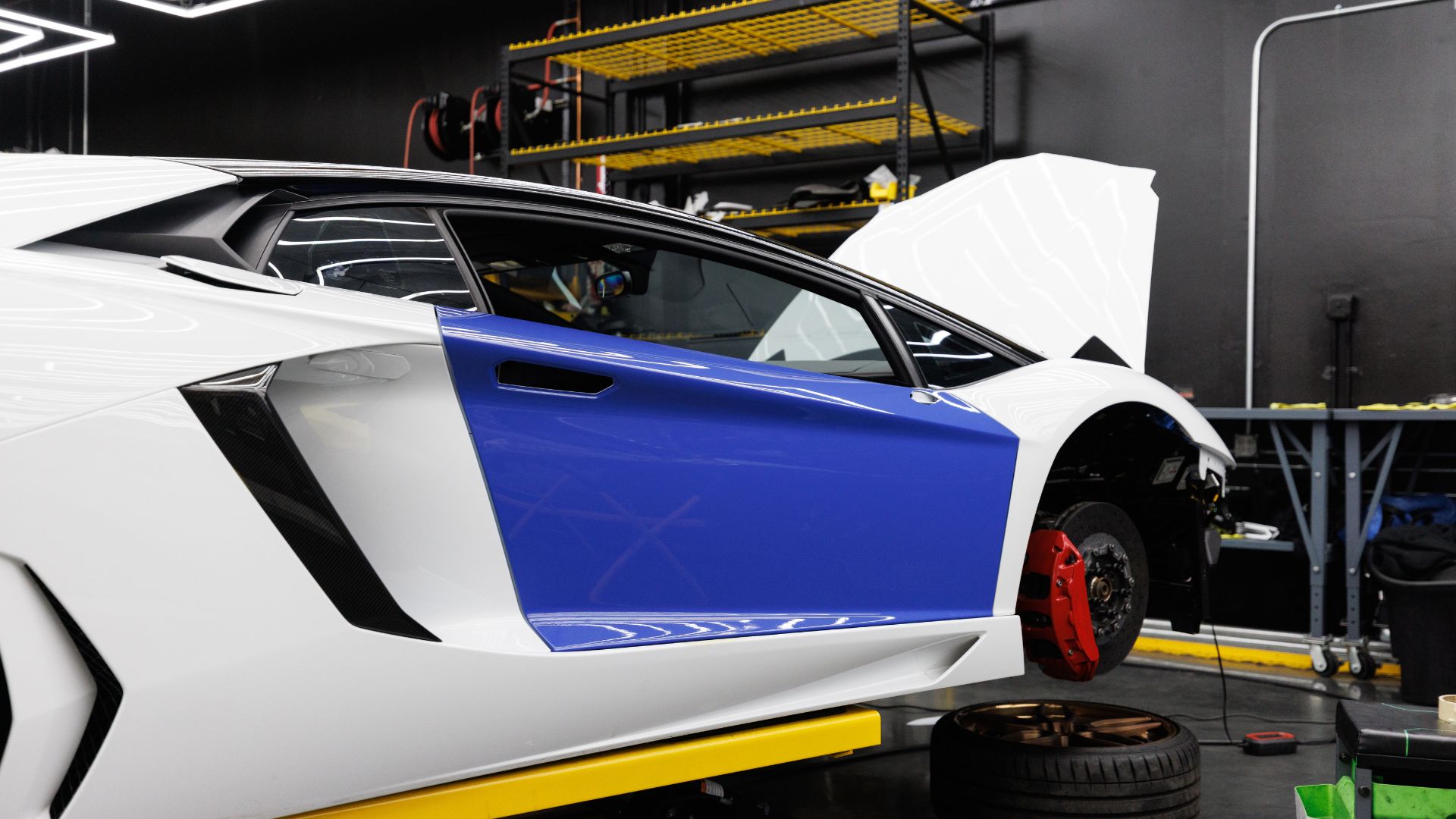 White and blue supercar with open door in automotive workshop