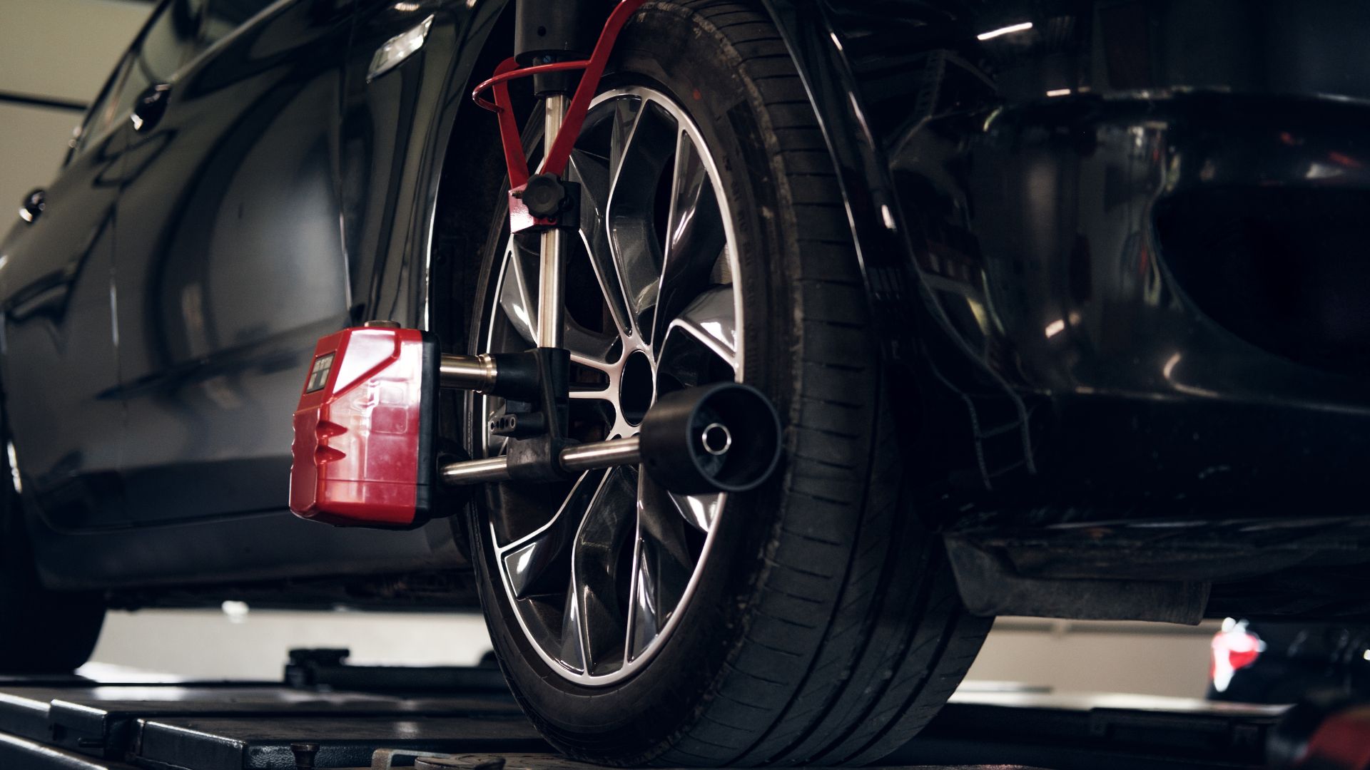 Car wheel with alignment machine during professional automotive service